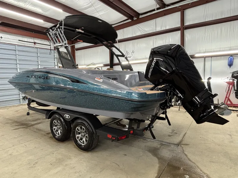 Slide: The Image of 2026 Tahoe Deck 2150 boat in warehouse with trailer. - 6