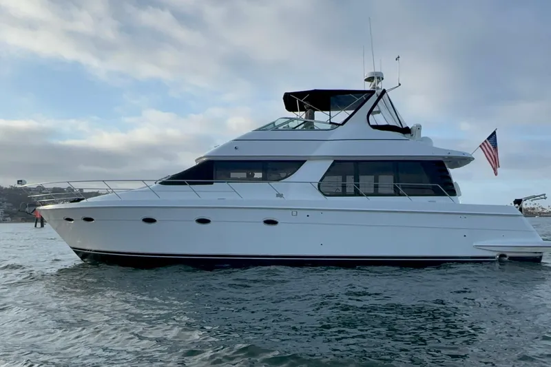 The Image of 2000 Carver 530 Voyager Pilothouse yacht on water, side view with American flag. - 0