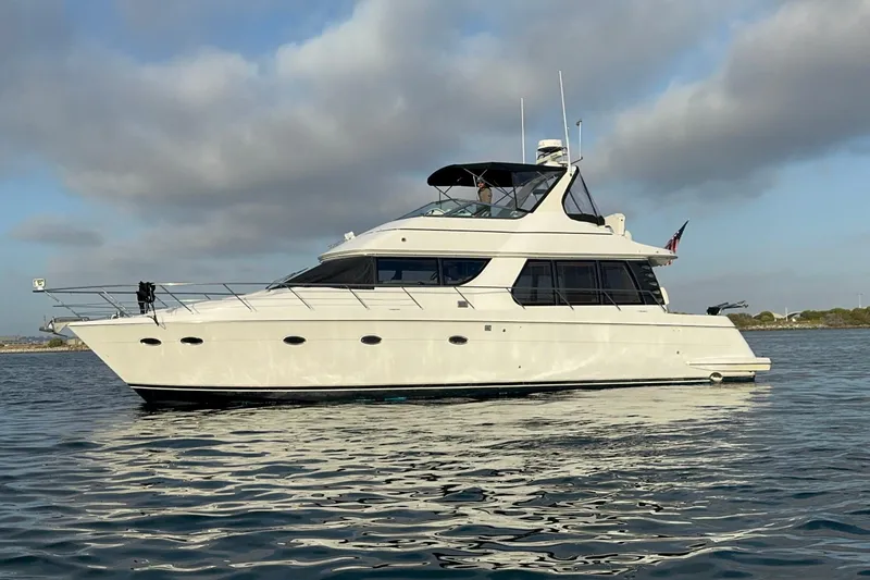 Slide: The Image of 2000 Carver 530 Voyager Pilothouse yacht on calm water under cloudy sky. - 13