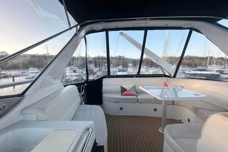 Slide: The Image of Interior of 2000 Carver 530 Voyager Pilothouse with seating and table, overlooking marina. - 20