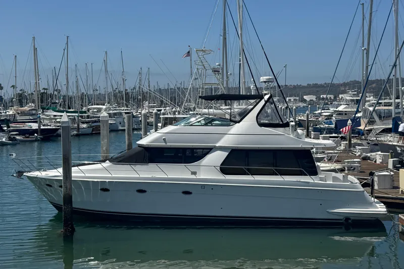 Slide: The Image of 2000 Carver 530 Voyager Pilothouse yacht docked in a marina with sailboats. - 5