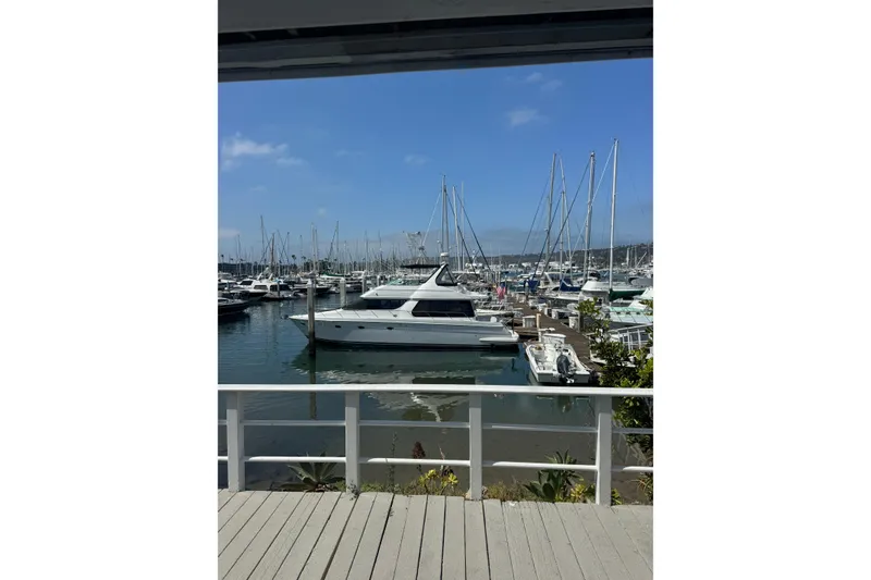 Slide: The Image of 2000 Carver 530 Voyager Pilothouse yacht docked in a marina under a clear blue sky. - 6