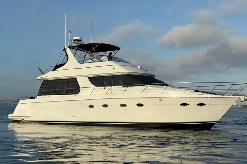 Slide: The Image of 2000 Carver 530 Voyager Pilothouse yacht cruising on calm waters under a clear sky. - 7