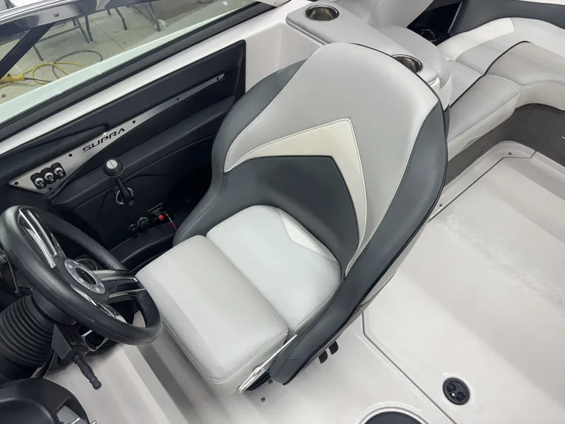 Slide: The Image of Interior of a 2013 Supra Launch SA350 boat with steering wheel and seat. - 11