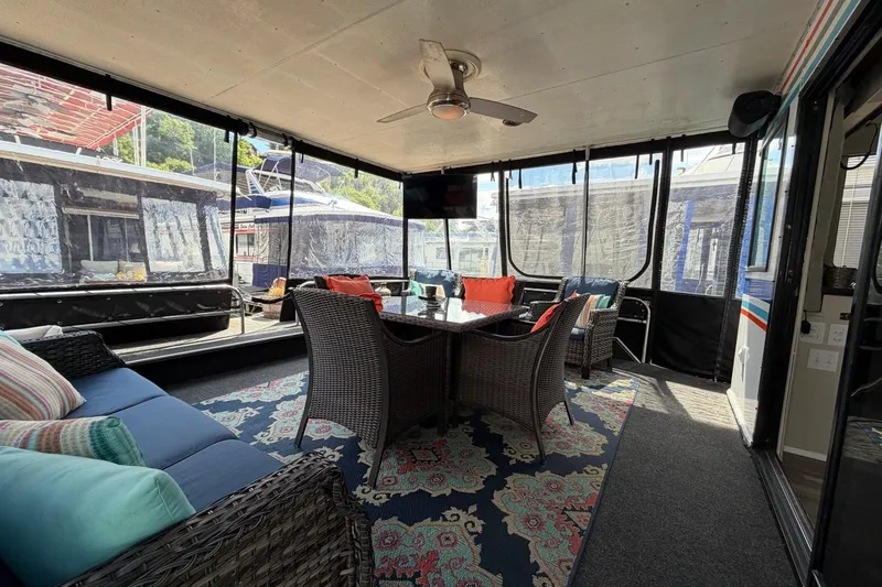 Slide: The Image of Cozy 1988 STARDUST 16x70 houseboat interior with wicker furniture and colorful cushions. - 1