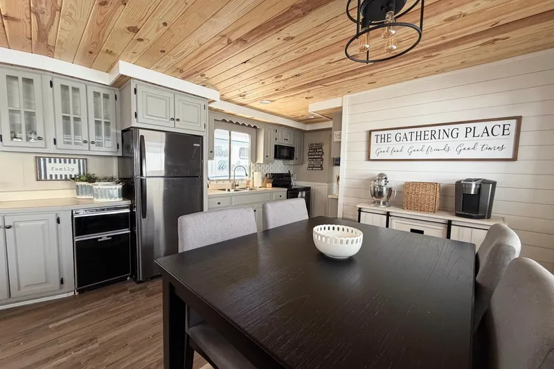 Slide: The Image of Cozy kitchen in a 1988 STARDUST 16x70 houseboat with modern decor and wooden ceiling. - 13