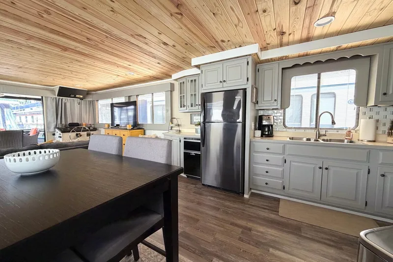 Slide: The Image of Interior of a 1988 STARDUST 16x70 houseboat with modern kitchen and dining area. - 14