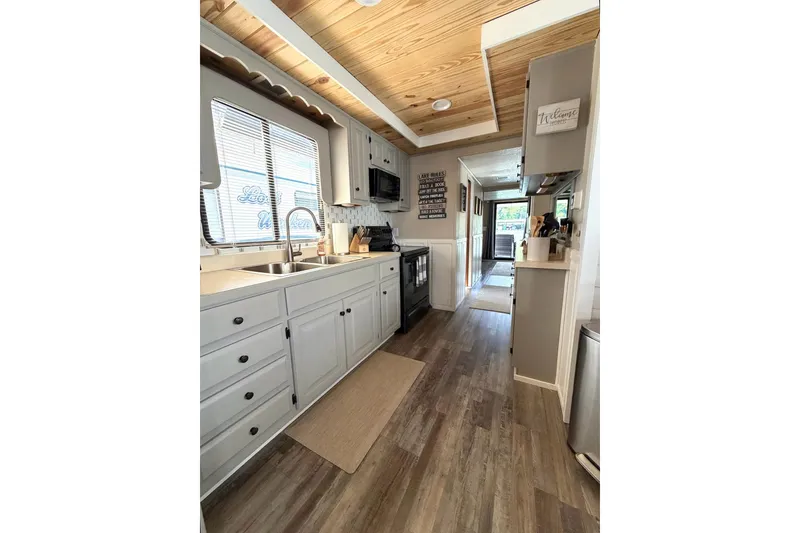 Slide: The Image of Modern kitchen interior in 1988 STARDUST 16x70 houseboat with wood ceiling and sleek cabinetry. - 17