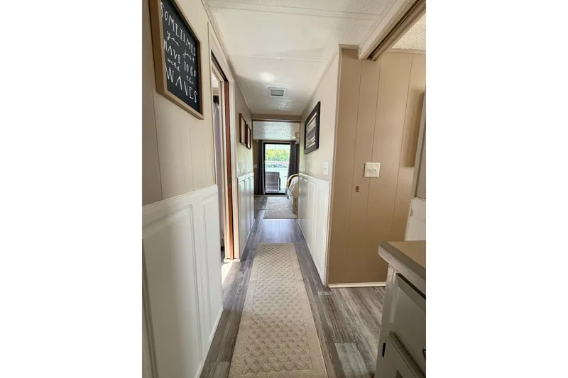 Slide: The Image of Narrow hallway in a 1988 STARDUST 16x70 houseboat with wood paneling and decor. - 18