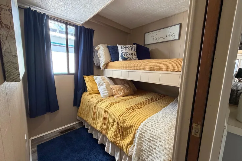 Slide: The Image of Cozy bedroom with bunk beds, yellow bedding, and decorative pillows in a 1988 STARDUST 16x70. - 19