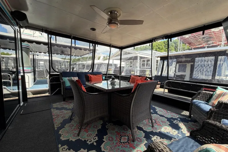 Slide: The Image of Enclosed deck area on 1988 STARDUST 16x70 houseboat with wicker furniture and ceiling fan. - 2