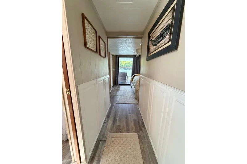 Slide: The Image of Hallway in 1988 STARDUST 16x70 houseboat with framed artwork and wood flooring. - 22