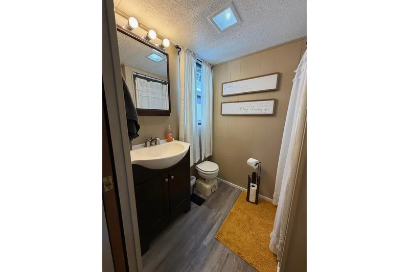Slide: The Image of Small bathroom in a 1988 STARDUST 16x70 houseboat with modern fixtures and decor. - 23
