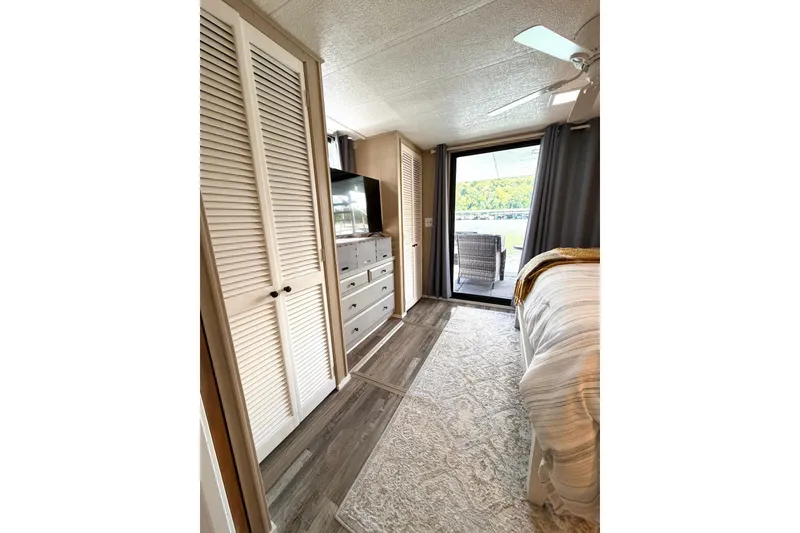 Slide: The Image of Cozy bedroom in 1988 STARDUST 16x70 houseboat with modern decor and outdoor view. - 25