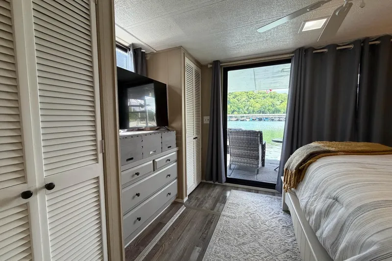 Slide: The Image of Cozy bedroom in 1988 STARDUST 16x70 houseboat with lake view and modern decor. - 28