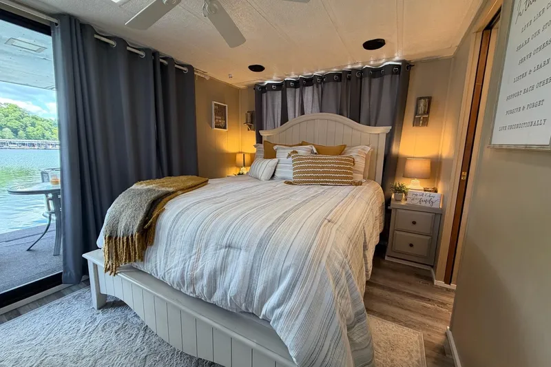 Slide: The Image of Cozy bedroom on 1988 STARDUST 16x70 houseboat with lake view and elegant decor. - 31