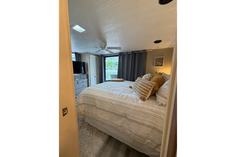 Slide: The Image of Cozy bedroom in 1988 STARDUST 16x70 houseboat with modern decor and natural light. - 32
