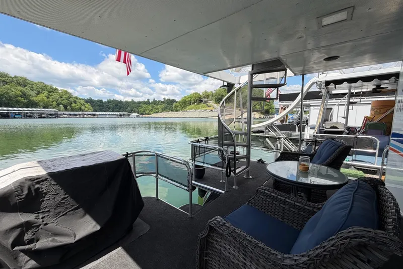 Slide: The Image of Covered deck of 1988 STARDUST 16x70 houseboat with outdoor seating and lake view. - 36