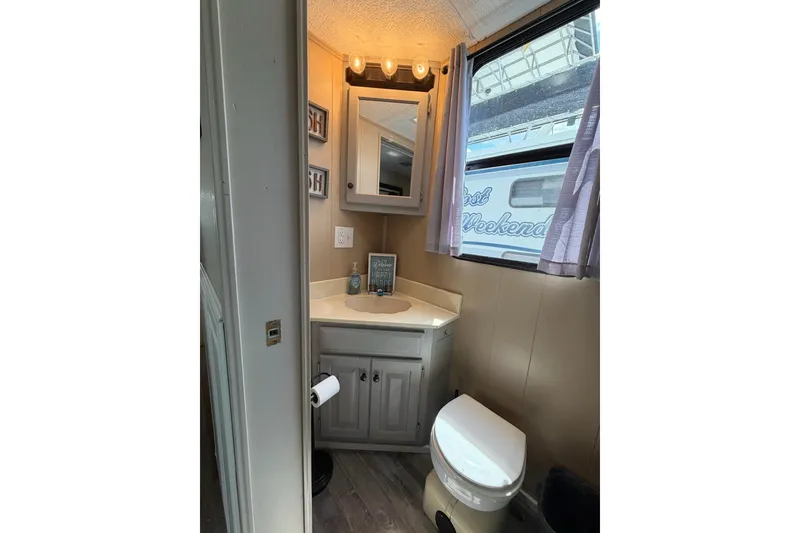 Slide: The Image of Bathroom interior of a 1988 STARDUST 16x70 houseboat with vanity and toilet. - 42