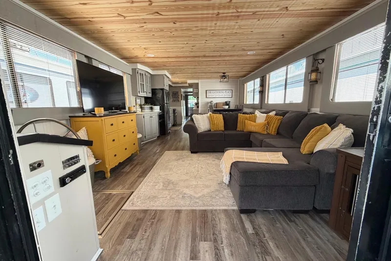Slide: The Image of Cozy houseboat interior with sectional sofa, yellow accents, and wood ceiling, STARDUST 16x70, 1988. - 5