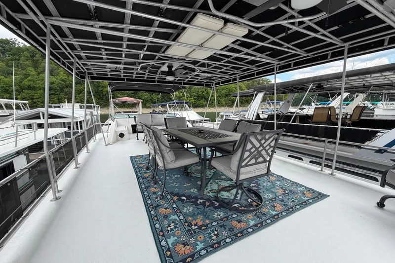 Slide: The Image of Upper deck of 1988 STARDUST 16x70 houseboat with dining area and scenic marina view. - 52