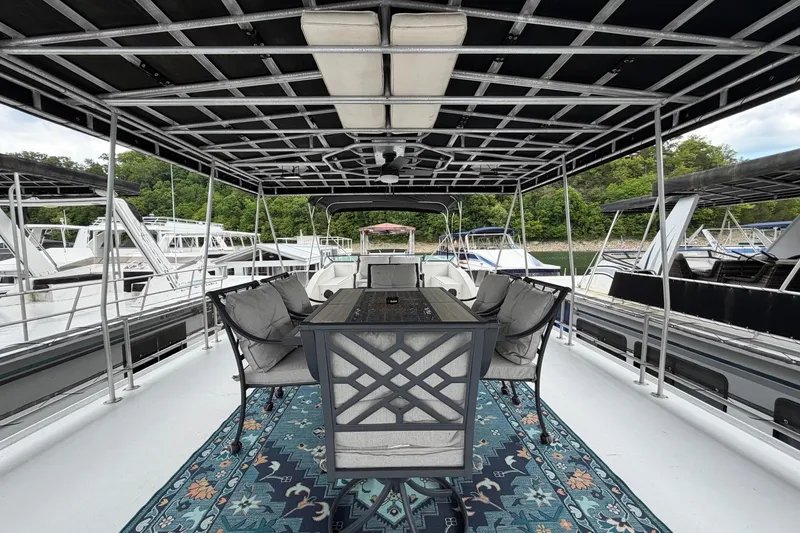 Slide: The Image of Covered deck of 1988 STARDUST 16x70 houseboat with outdoor seating and scenic view. - 53