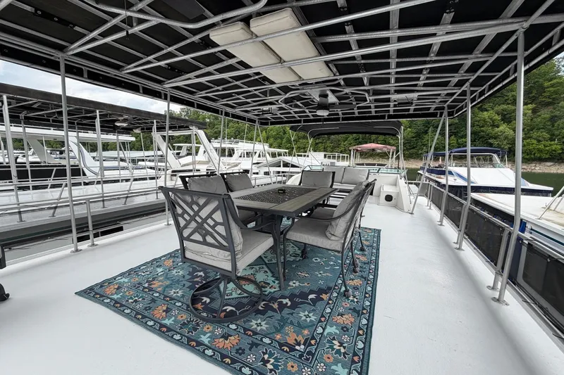 Slide: The Image of Spacious deck of 1988 STARDUST 16x70 houseboat with outdoor dining area and scenic marina view. - 54