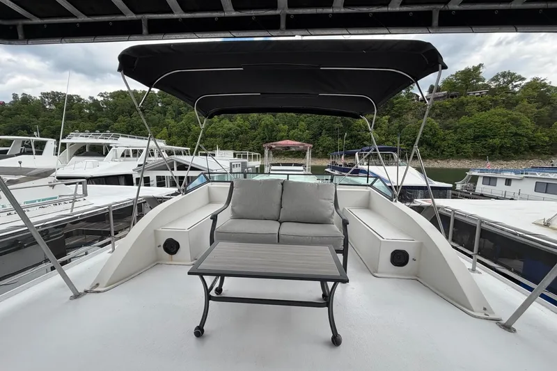 Slide: The Image of 1988 STARDUST 16x70 houseboat deck with canopy, sofa, and table, docked at marina. - 55