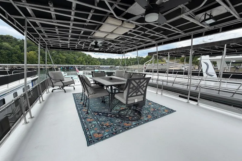 Slide: The Image of Spacious deck on 1988 STARDUST 16x70 houseboat with outdoor seating and scenic marina view. - 56