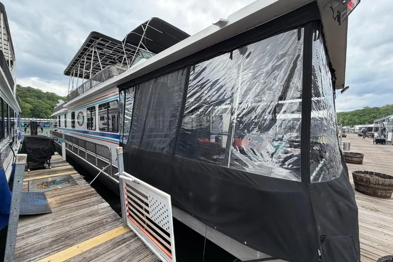 Slide: The Image of 1988 STARDUST 16x70 houseboat docked with clear weatherproof panels. - 59