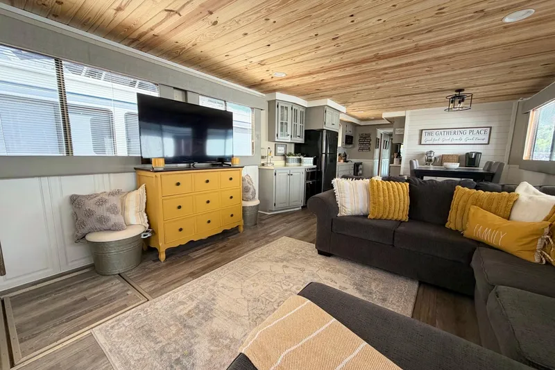 Slide: The Image of Cozy houseboat interior with modern decor, featuring a yellow dresser, gray sofa, and wooden ceiling. - 7