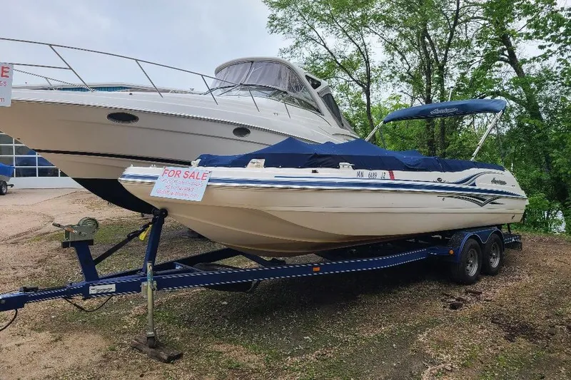 Slide: The Image of 2006 Hurricane SunDeck 257 DC IO boat for sale on trailer, parked outdoors. - 1