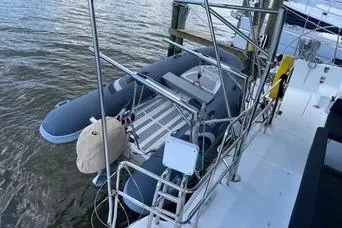 Slide: The Image of 2018 Lagoon 400 S2 yacht with attached inflatable dinghy at dockside. - 10