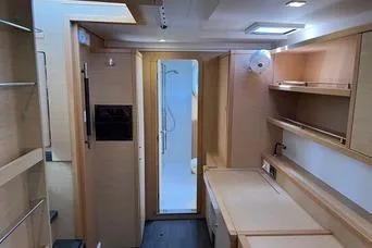 Slide: The Image of Interior of 2018 Lagoon 400 S2 yacht, featuring modern wood cabinetry and a compact shower area. - 18