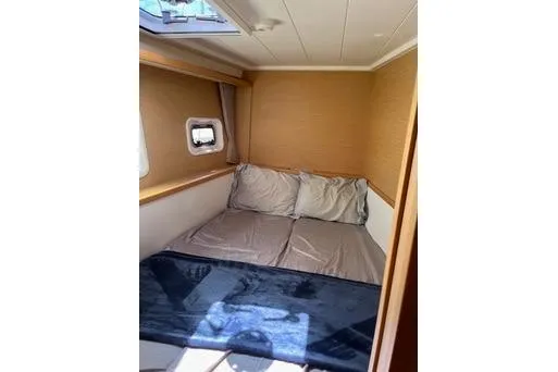Slide: The Image of Cozy cabin interior of 2018 Lagoon 400 S2 catamaran with bed and window. - 23