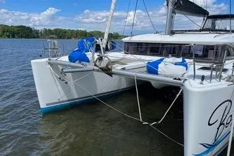 Slide: The Image of 2018 Lagoon 400 S2 catamaran docked on a serene lake with blue skies. - 27