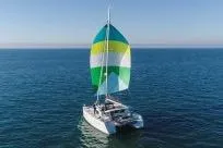Slide: The Image of 2018 Lagoon 400 S2 catamaran sailing with colorful spinnaker on open sea. - 3