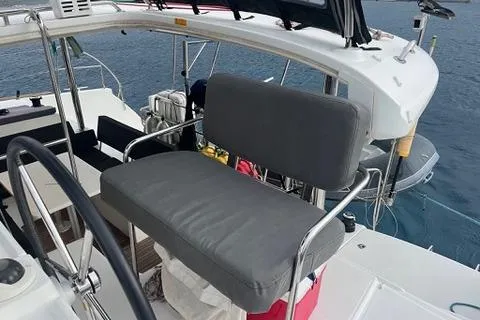 Slide: The Image of 2018 Lagoon 400 S2 yacht helm station with cushioned seating and ocean backdrop. - 31