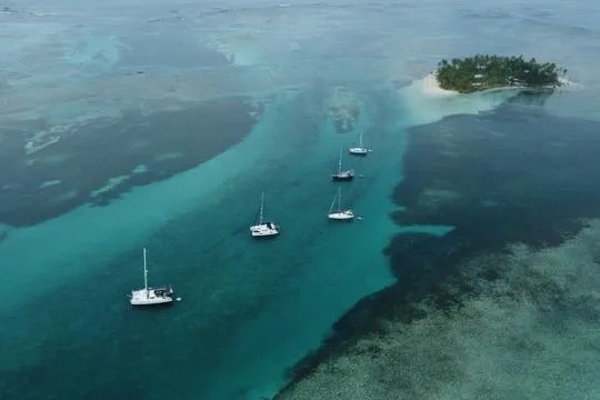 Slide: The Image of Aerial view of Lagoon 400 S2 catamarans near a tropical island, 2018. - 5