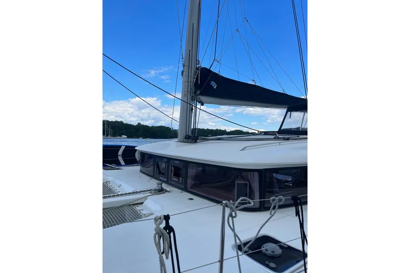 Slide: The Image of 2018 Lagoon 400 S2 catamaran with sails, docked under a clear blue sky. - 7