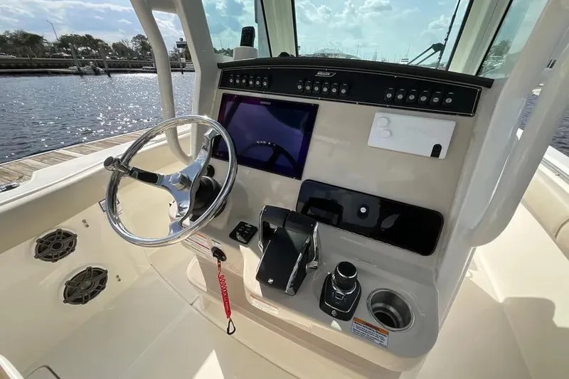 Slide: The Image of 2024 Boston Whaler 280 Outrage helm with steering wheel and control panel. - 10