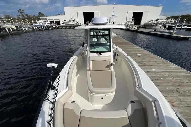 Slide: The Image of 2024 Boston Whaler 280 Outrage docked at marina, showcasing spacious deck and sleek design. - 14