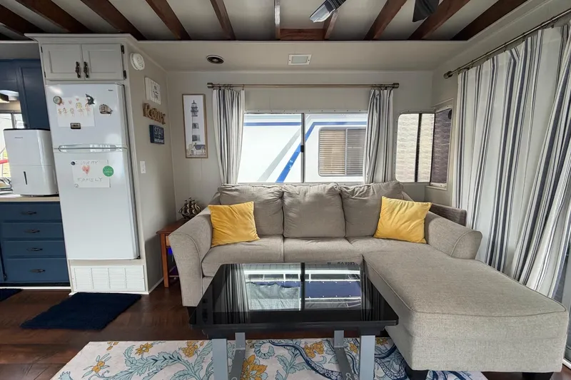 Slide: The Image of Cozy living area in 1987 Jamestowner houseboat with sofa, striped curtains, and decorative accents. - 12