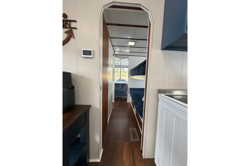 Slide: The Image of Interior hallway of a 1987 Jamestowner 14x60 houseboat with bunk beds and wood flooring. - 15