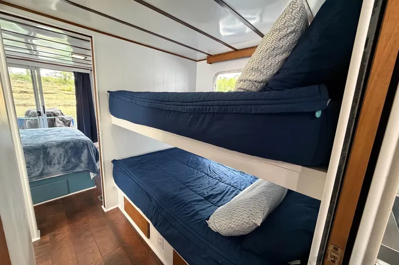 Slide: The Image of Bunk beds with blue bedding in a 1987 Jamestowner 14x60 houseboat interior. - 16