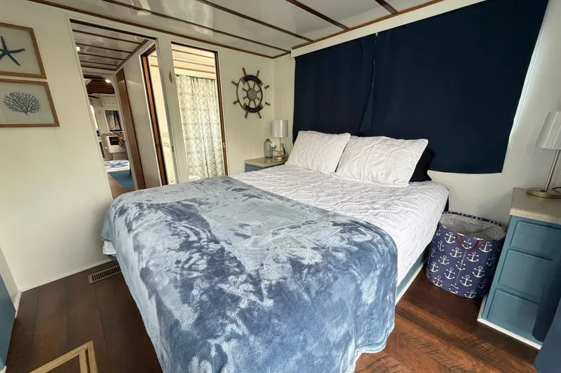 Slide: The Image of Cozy bedroom in 1987 Jamestowner houseboat with nautical decor and blue accents. - 17