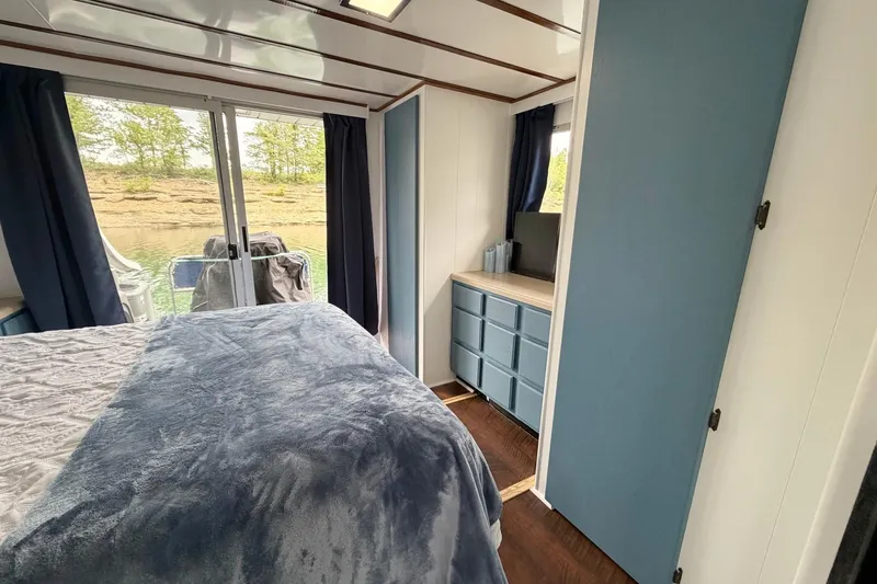 Slide: The Image of Cozy bedroom in a 1987 Jamestowner 14x60 houseboat with blue decor and river view. - 19