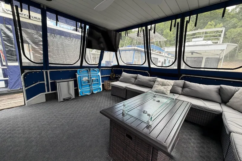 Slide: The Image of Interior of a 1987 Jamestowner 14x60 houseboat with cozy seating and a glass-top table. - 2