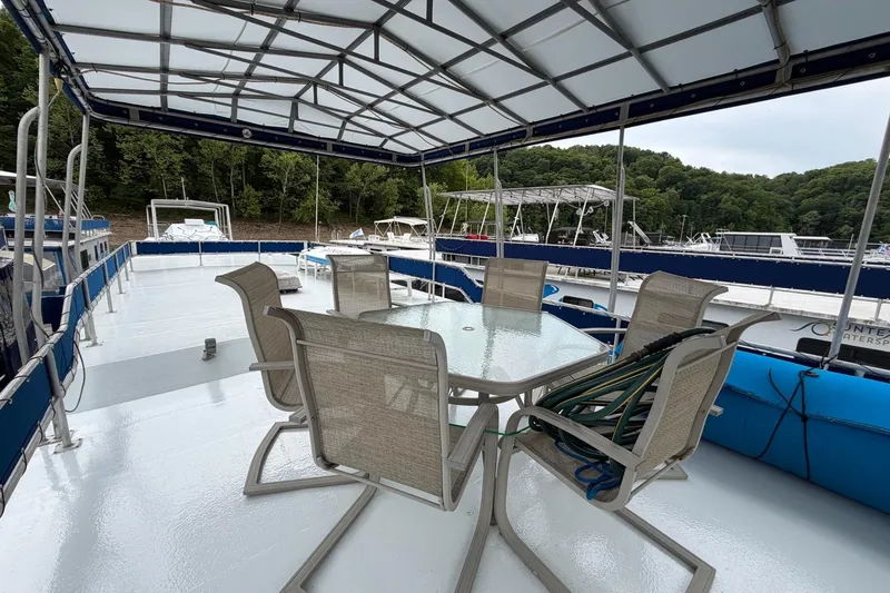 Slide: The Image of Covered deck of 1987 Jamestowner 14x60 houseboat with outdoor seating and marina view. - 22