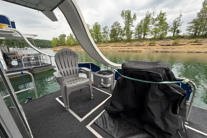 Slide: The Image of 1987 Jamestowner 14x60 houseboat deck with chair, grill, and scenic lake view. - 29